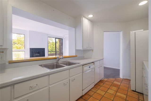 1707 Spyglass Dr Unit 57, Austin, TX 78746 - kitchen featuring white appliances, a sink, light countertops, white cabinets, and a fireplace