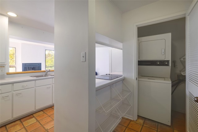 laundry room featuring sink and stacked washer / drying machine