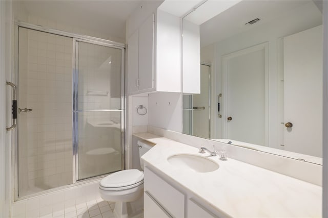 bathroom featuring tile patterned flooring, vanity, toilet, and a shower with door