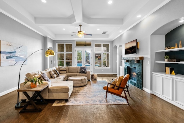 living room with a tile fireplace, ceiling fan, dark wood-type flooring, and french doors