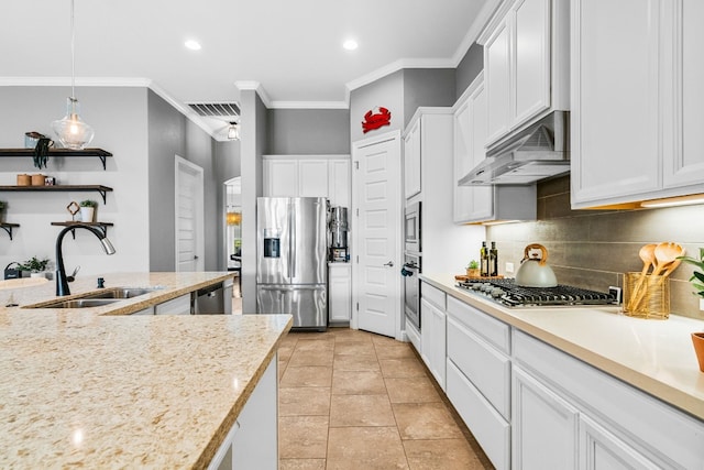 kitchen with appliances with stainless steel finishes, white cabinetry, sink, and decorative light fixtures