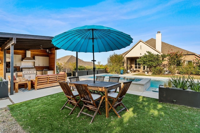 exterior space featuring a yard, a patio, and exterior kitchen