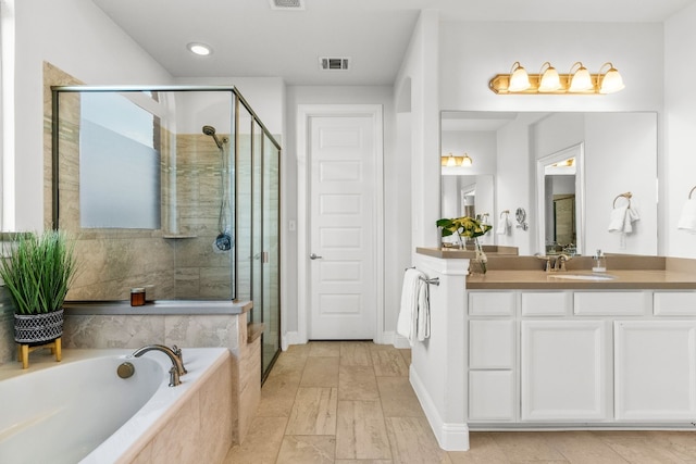 bathroom with vanity and separate shower and tub