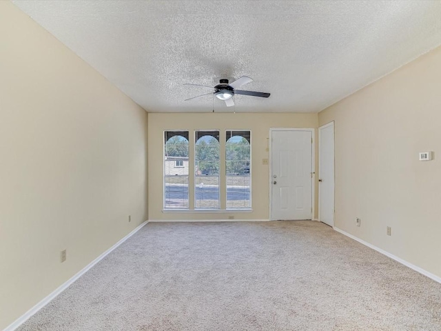 carpeted spare room featuring ceiling fan and a textured ceiling