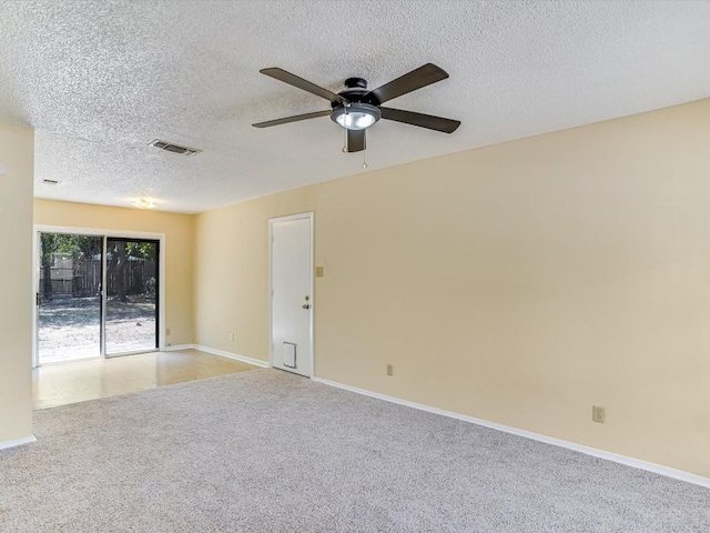 carpeted empty room with ceiling fan and a textured ceiling