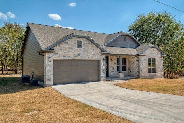 view of front of home with a front lawn, central air condition unit, and a garage