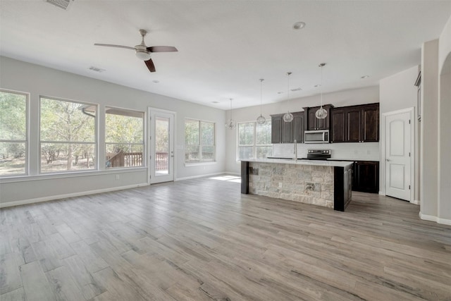 kitchen featuring light hardwood / wood-style floors, stainless steel appliances, a center island, ceiling fan, and decorative light fixtures