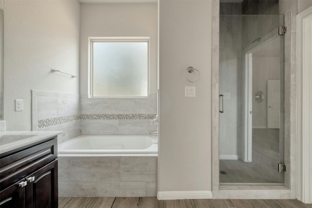 bathroom with independent shower and bath, vanity, and hardwood / wood-style floors