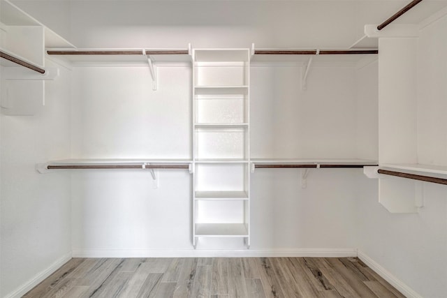 walk in closet with light hardwood / wood-style flooring