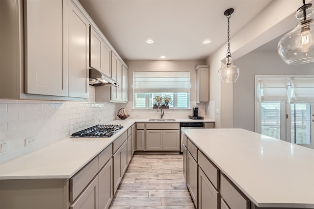 kitchen featuring appliances with stainless steel finishes, tasteful backsplash, gray cabinets, light hardwood / wood-style flooring, and sink