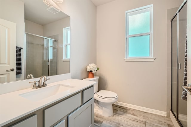 bathroom featuring hardwood / wood-style floors, a shower with door, vanity, and toilet