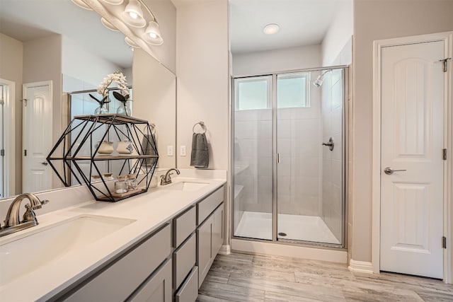 bathroom with an enclosed shower, hardwood / wood-style flooring, and vanity