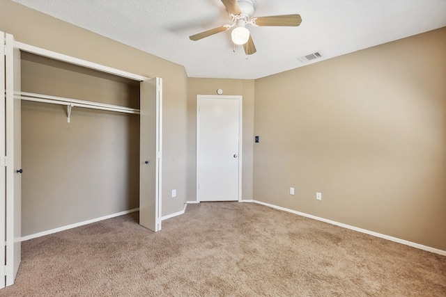 unfurnished bedroom with a closet, carpet, and ceiling fan