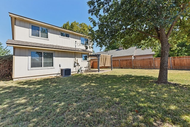 back of house featuring a yard and central air condition unit