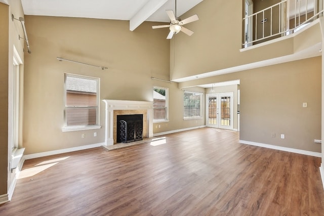 unfurnished living room featuring ceiling fan, hardwood / wood-style floors, beamed ceiling, and high vaulted ceiling