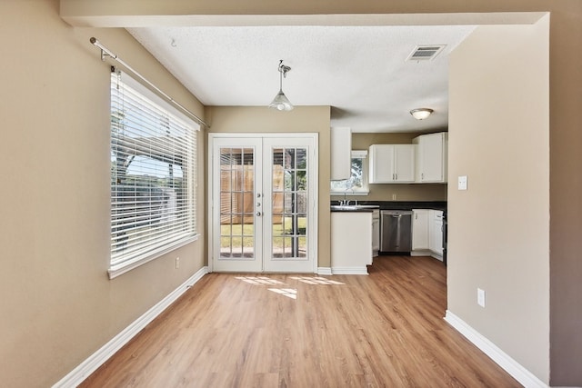 interior space featuring light wood-type flooring, a textured ceiling, french doors, and sink