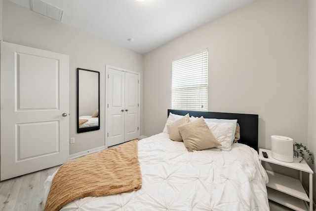 bedroom with light wood-type flooring and a closet