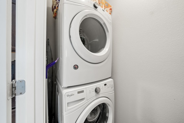 clothes washing area featuring stacked washing maching and dryer