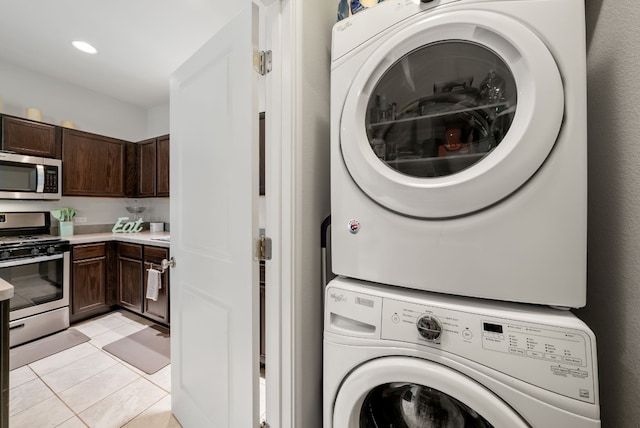 laundry room with stacked washer / drying machine and light tile patterned floors