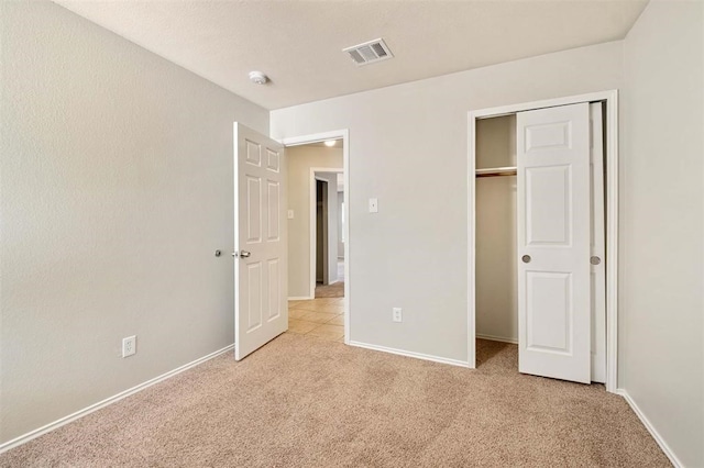 unfurnished bedroom featuring a closet and light carpet