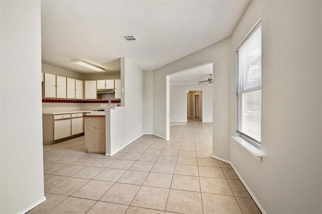 kitchen with backsplash, kitchen peninsula, light tile patterned floors, and ceiling fan