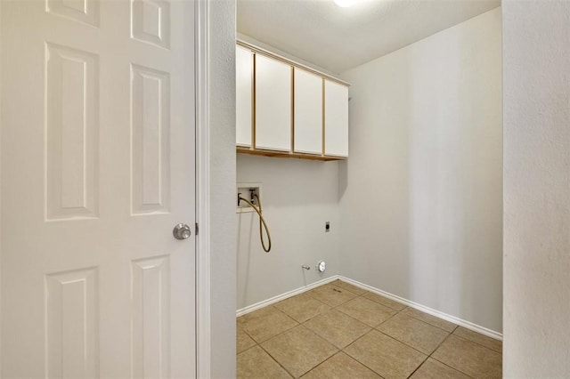 laundry area featuring hookup for an electric dryer, light tile patterned flooring, gas dryer hookup, and cabinets