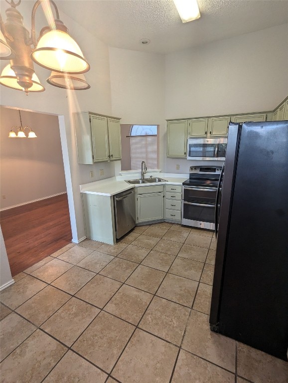 kitchen featuring pendant lighting, light tile patterned flooring, sink, a chandelier, and appliances with stainless steel finishes