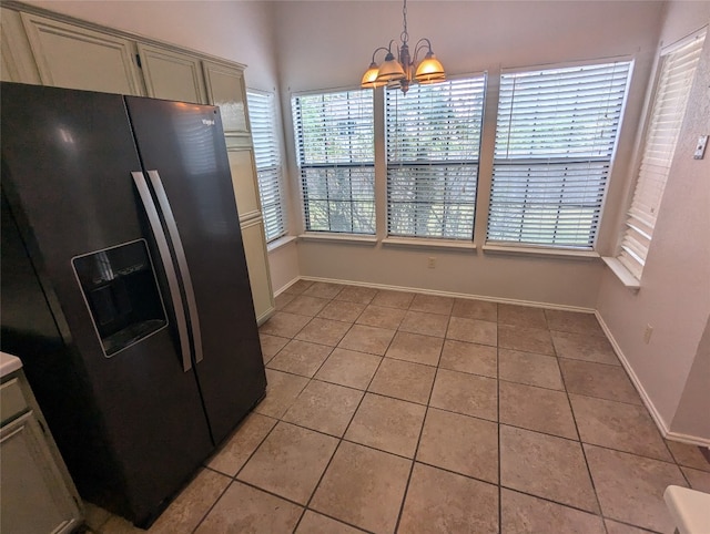 kitchen with hanging light fixtures, cream cabinetry, light tile patterned floors, stainless steel refrigerator with ice dispenser, and a notable chandelier