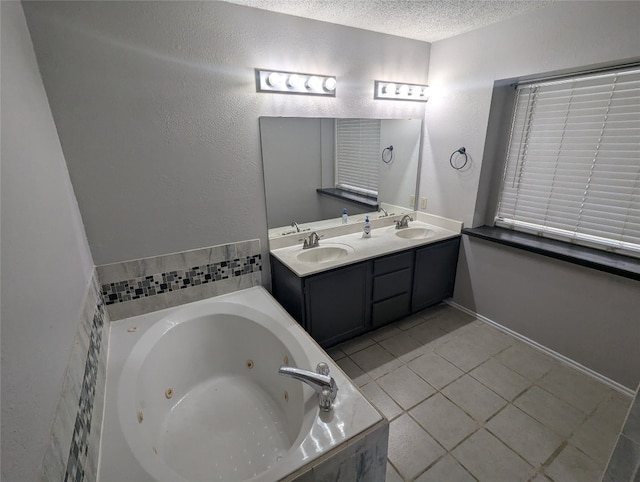 bathroom with vanity, a relaxing tiled tub, tile patterned flooring, and a textured ceiling