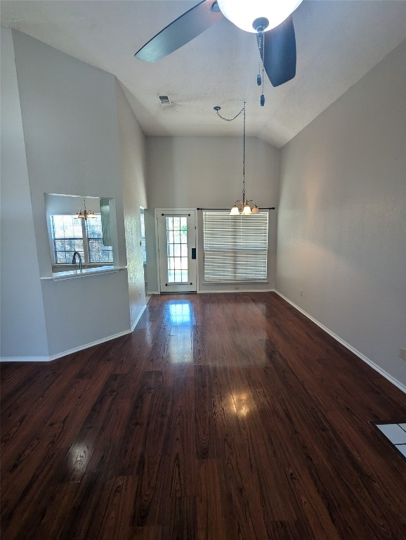 unfurnished living room with ceiling fan with notable chandelier, lofted ceiling, dark hardwood / wood-style floors, and sink