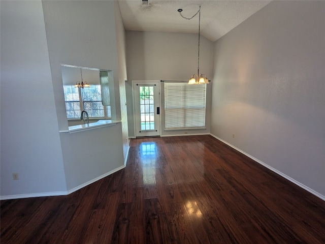 unfurnished dining area featuring a textured ceiling, dark hardwood / wood-style flooring, high vaulted ceiling, and a notable chandelier