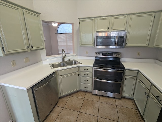 kitchen with appliances with stainless steel finishes, sink, light tile patterned floors, and ceiling fan