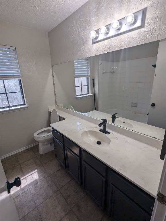 bathroom featuring a wealth of natural light, a textured ceiling, vanity, and toilet