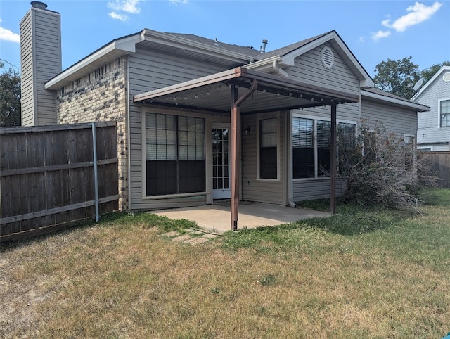 back of property featuring a yard and a patio area