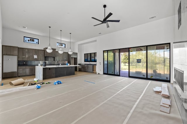 living room with a high ceiling, ceiling fan, and sink