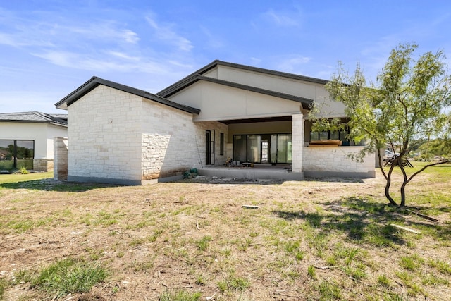 rear view of property featuring a lawn