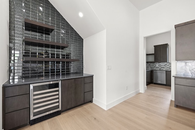 bar featuring dark brown cabinetry, dishwasher, light wood-type flooring, and beverage cooler