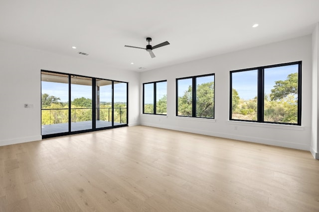 unfurnished room featuring light wood-type flooring, plenty of natural light, and ceiling fan