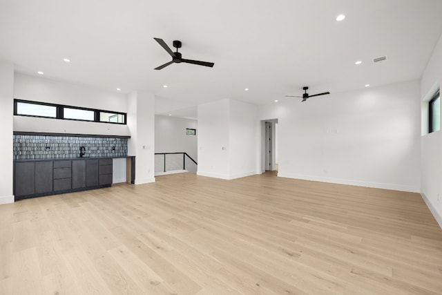 unfurnished living room featuring light hardwood / wood-style flooring and ceiling fan