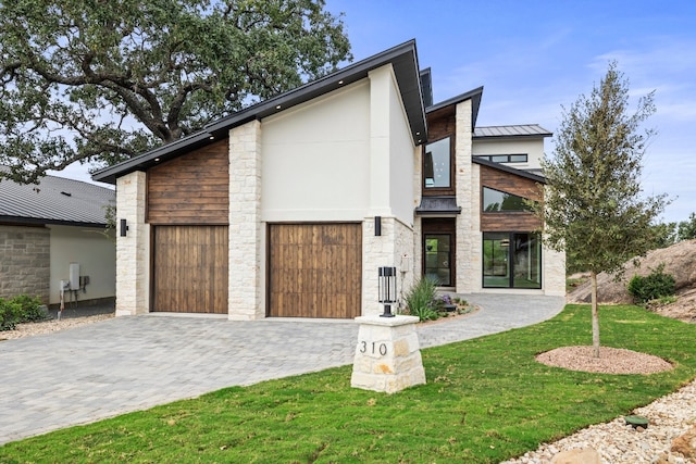 contemporary home featuring a front yard and a garage