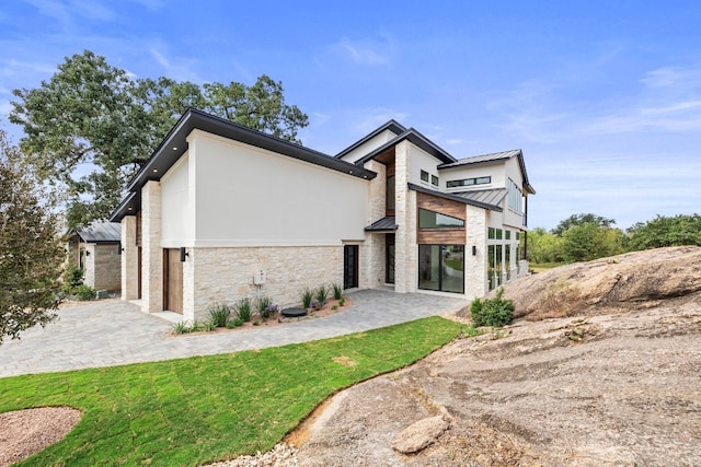 view of property exterior featuring a patio and a lawn