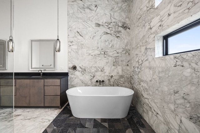 bathroom with vanity, tile walls, and a bathtub