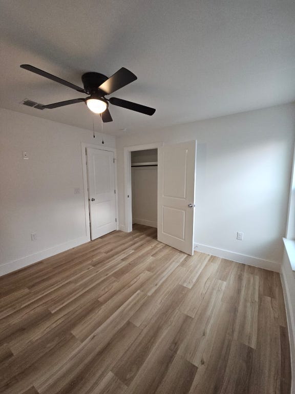 unfurnished bedroom with baseboards, light wood-type flooring, a closet, and ceiling fan