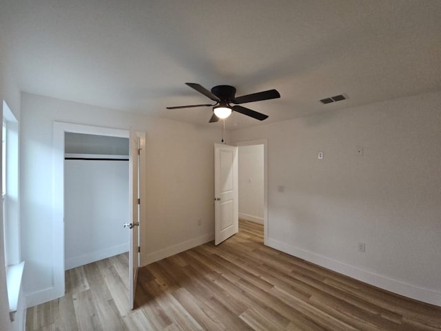 unfurnished bedroom featuring visible vents, baseboards, a closet, and light wood finished floors