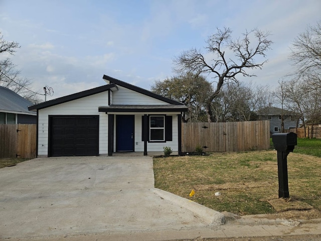 view of front of home featuring an attached garage, concrete driveway, a front lawn, and fence