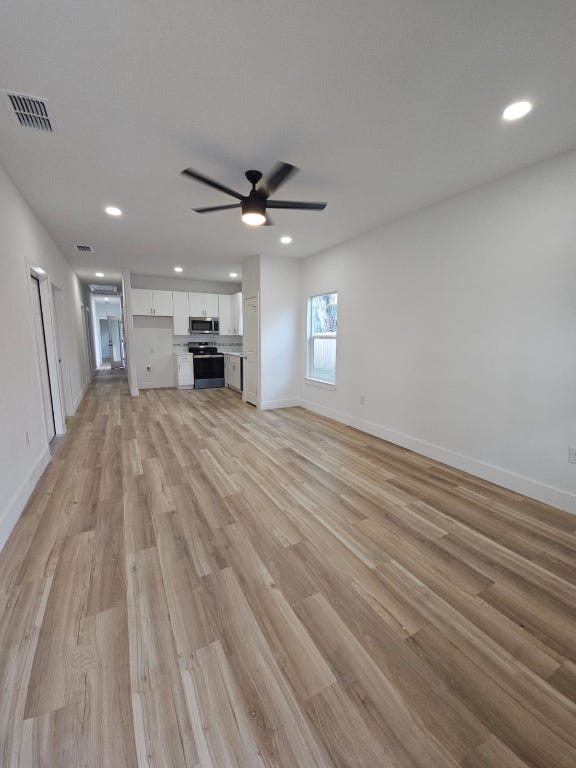 unfurnished living room featuring visible vents, light wood-style flooring, recessed lighting, baseboards, and ceiling fan