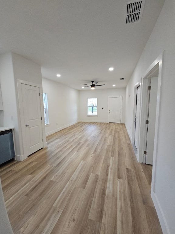 interior space featuring visible vents, a ceiling fan, recessed lighting, light wood-style floors, and baseboards