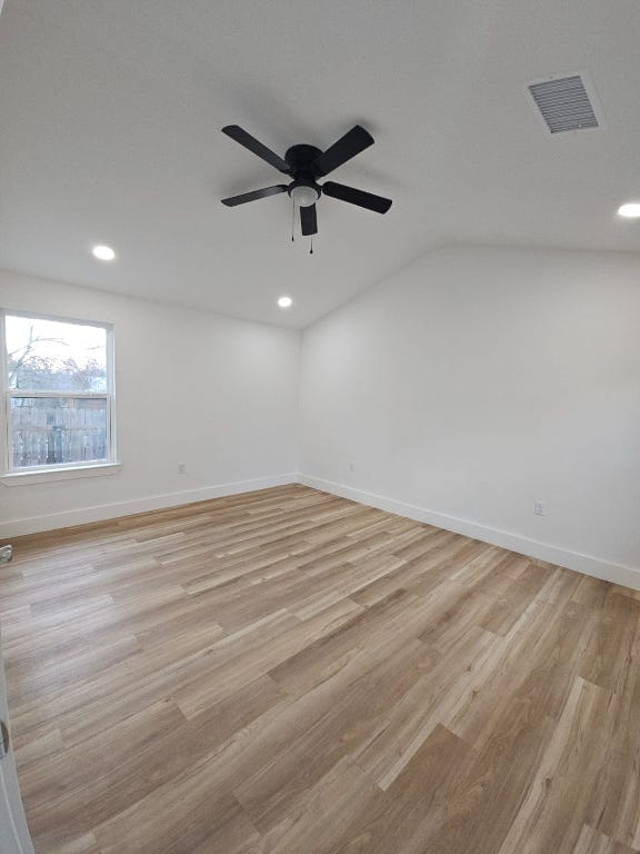 spare room with visible vents, light wood-style flooring, and baseboards