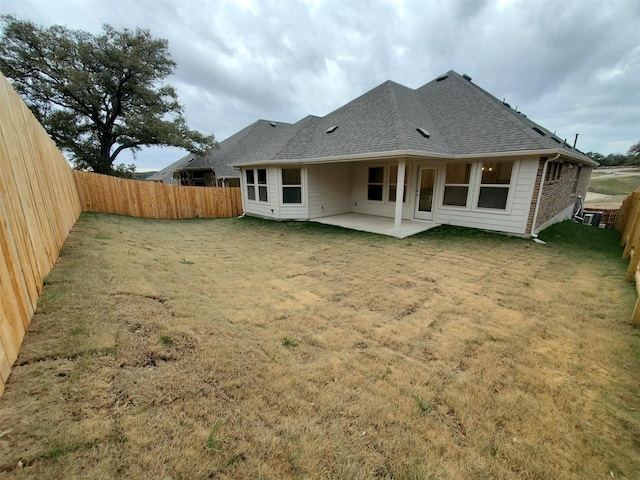 rear view of house with a patio and a yard