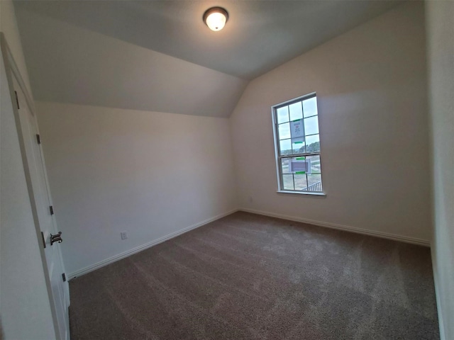 bonus room with vaulted ceiling and dark colored carpet